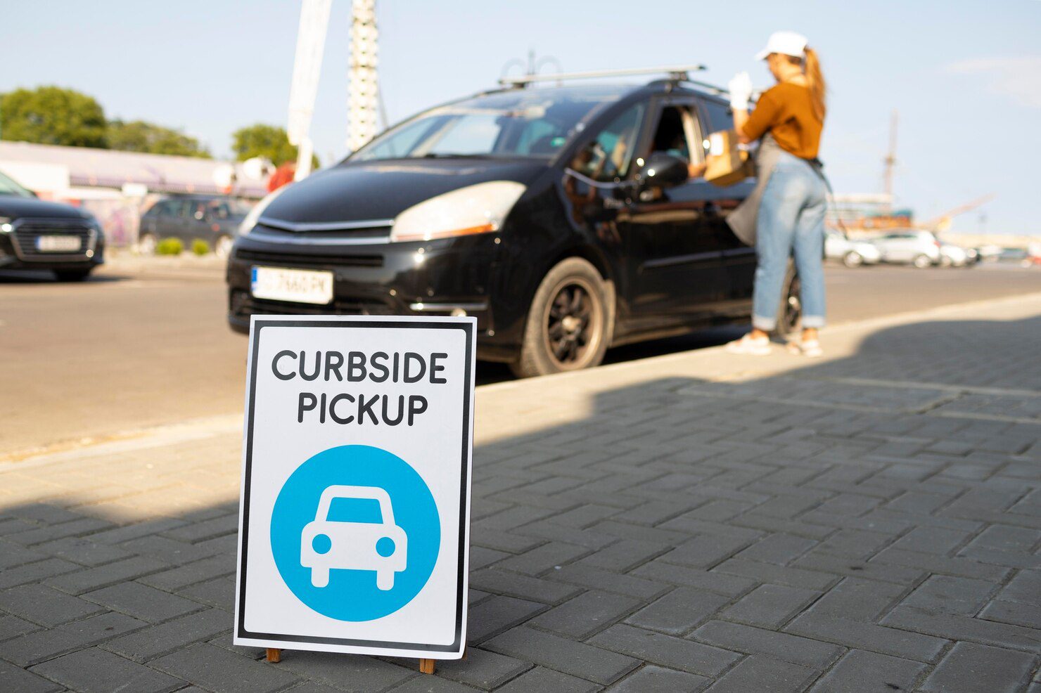 Curbside pickup sign with car pictogram at a storefront