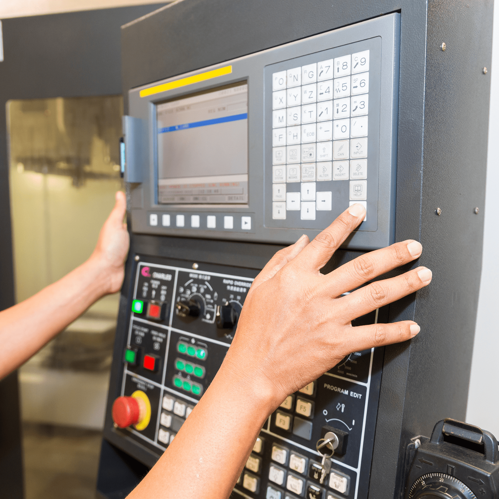 Operator using a CNC control panel with custom membrane keypad overlay